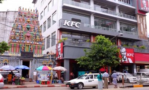 Welten treffen aufeinander: In Yangon nimmt man zum Essen an einem der vielen Straßenstände Platz (links). KFC bringt ein anderes Konzept nach Myanmar. 