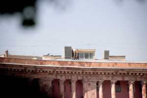 Sniper, die zum Schutz des Präsidenten auf den umliegenden Dächern positioniert sind, beobachten die Zeremonie - mit Zigarette in der Hand.